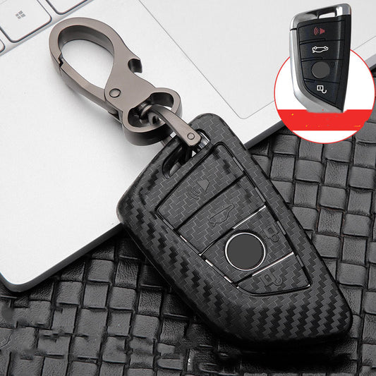 Replacement 4-button smart key case for BMW – carbon fibre case with keyring beside a laptop, inset of original key