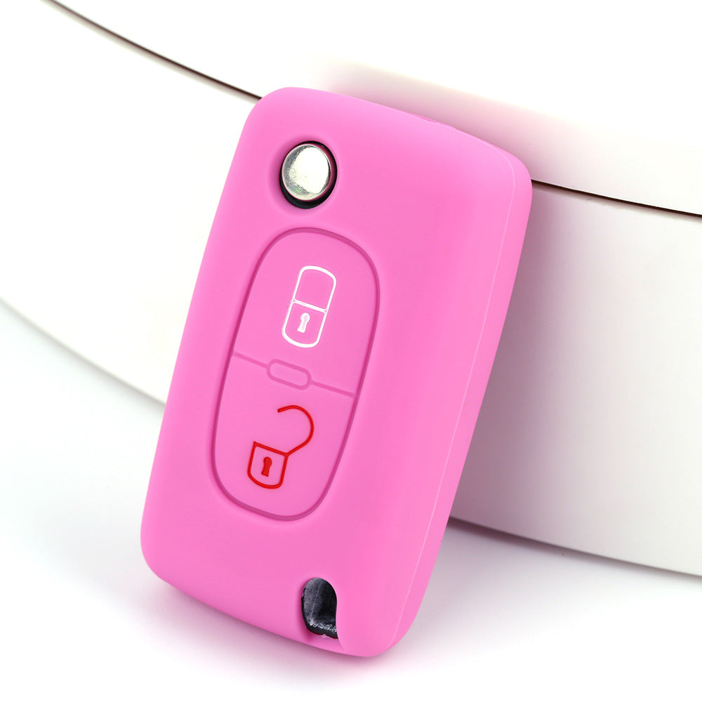 Key fob cover for Peugeot 2-button folding keys – silicone – pink silicone cover on white surface