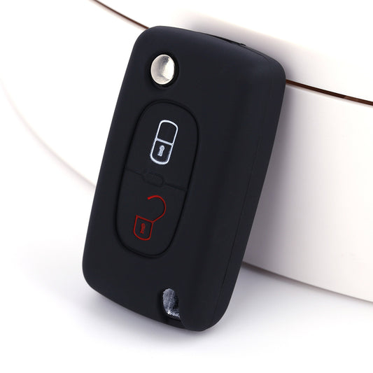Key fob cover for Peugeot 2-button folding keys – silicone – black silicone cover on white surface