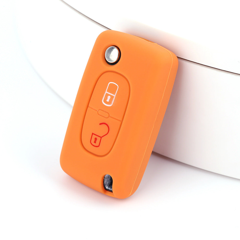 Key fob cover for Peugeot 2-button folding keys – silicone – orange silicone cover on white surface