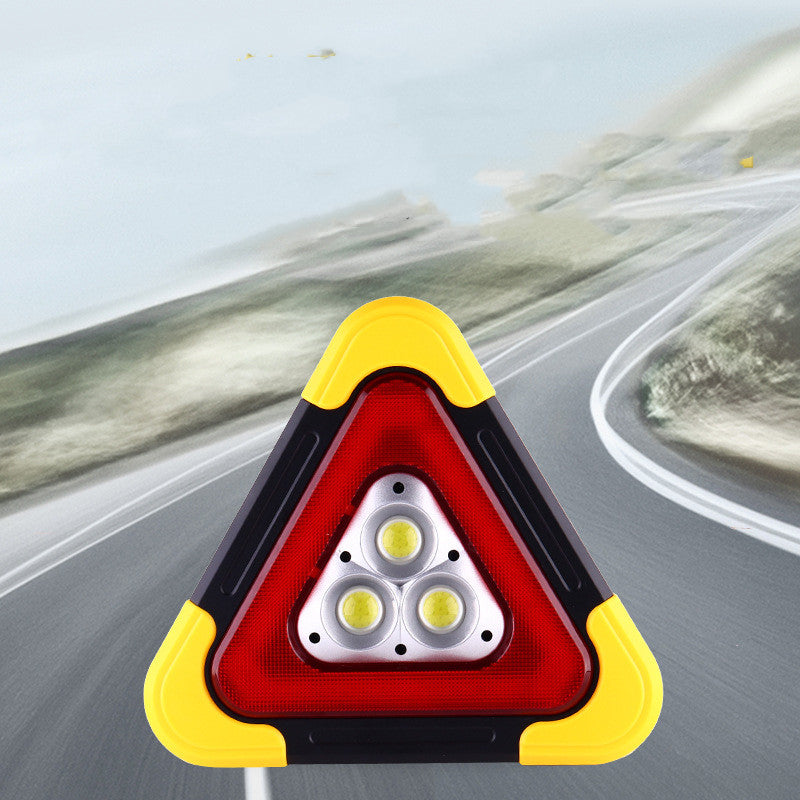 Folding tripod car warning triangle – standing on a road with daylight scene