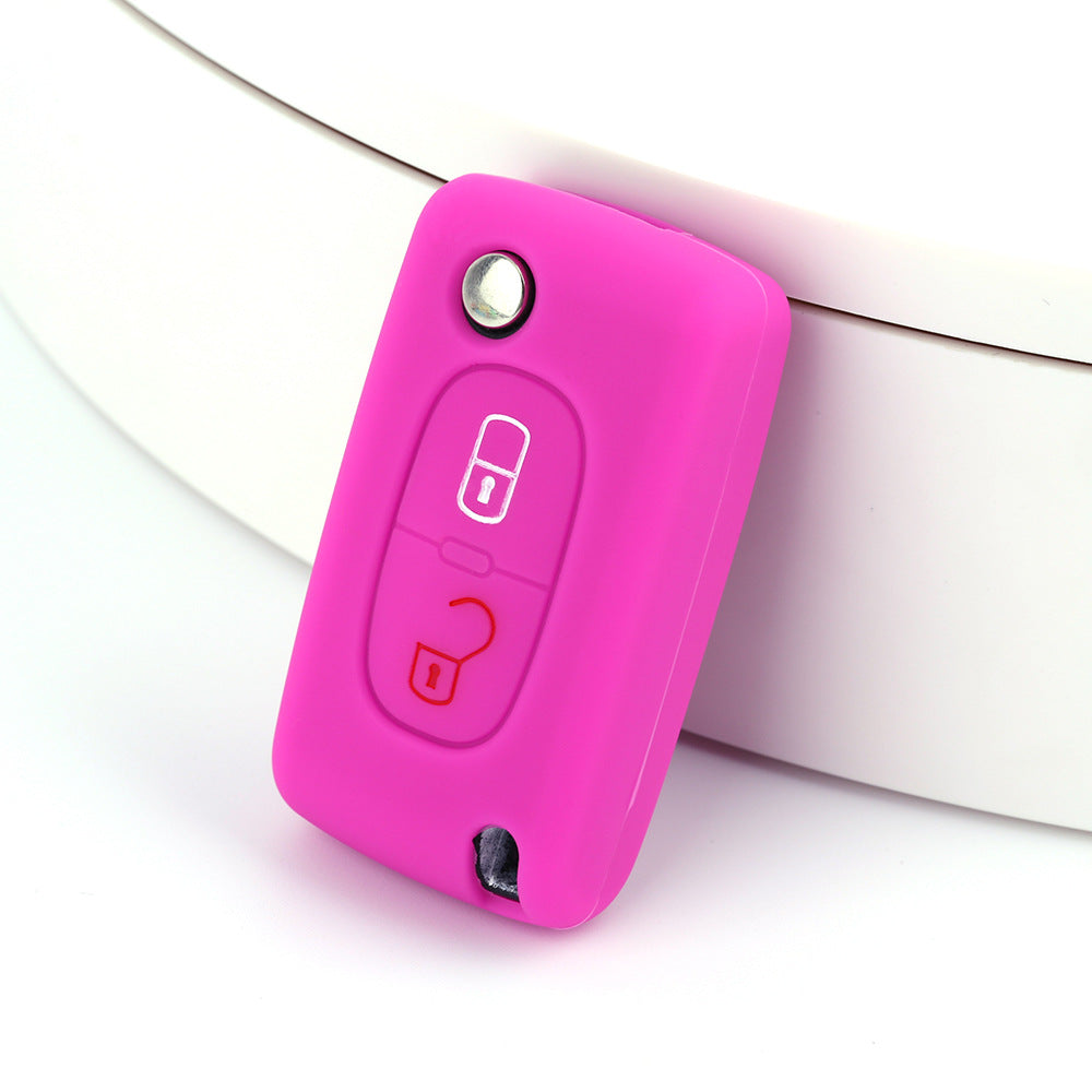 Key fob cover for Peugeot 2-button folding keys – silicone – magenta silicone cover on white surface