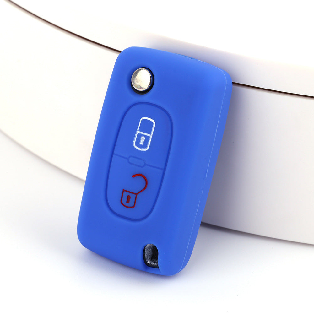 Key fob cover for Peugeot 2-button folding keys – silicone – blue silicone cover on white surface