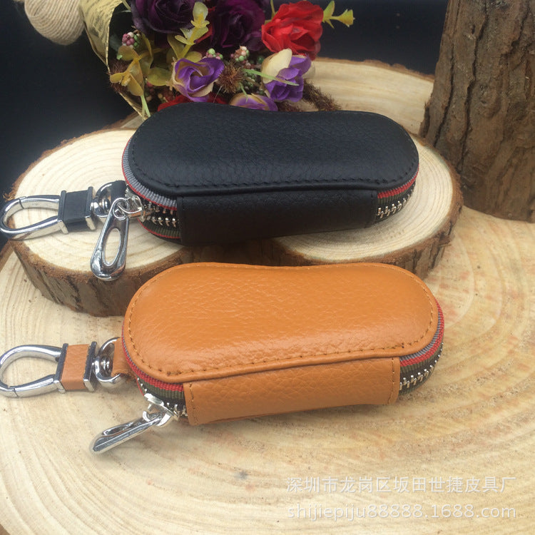 Leather zip car key case – universal – black and tan cases on a tree stump display