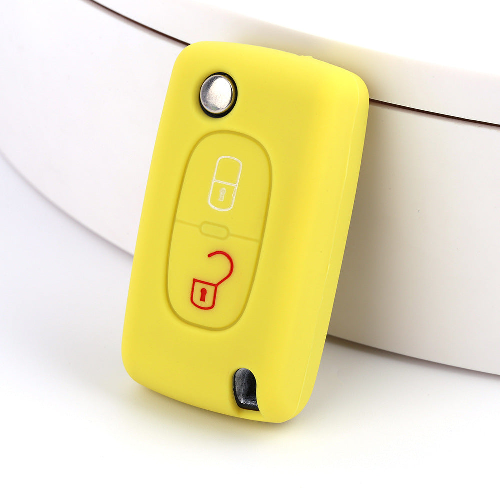 Key fob cover for Peugeot 2-button folding keys – silicone – yellow silicone cover on white surface