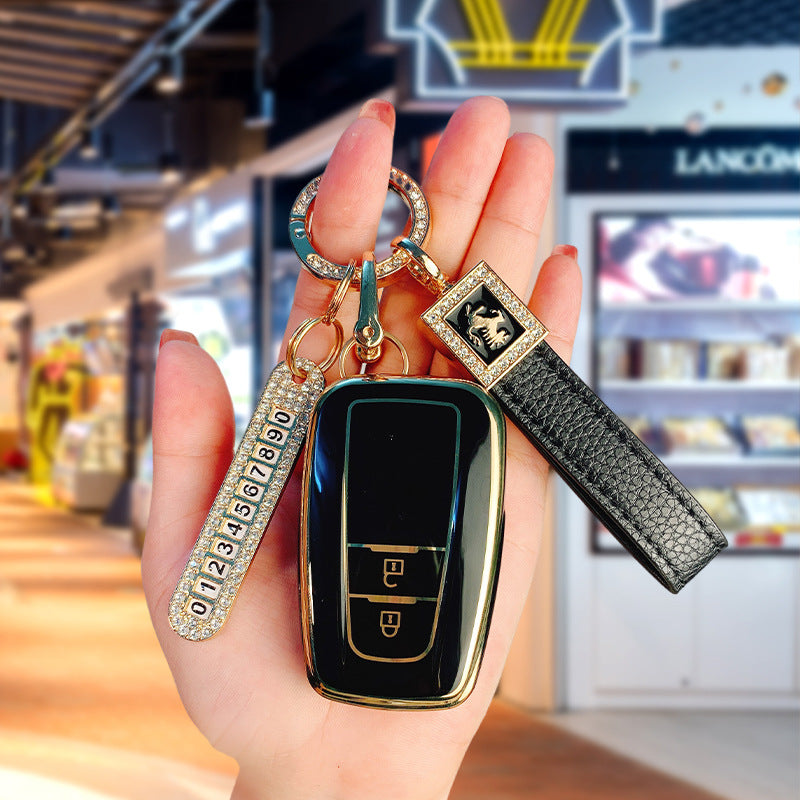 Key fob cover for Toyota 2-button keys – TPU – black and gold cover held with crystal keyring and black leather wrist strap