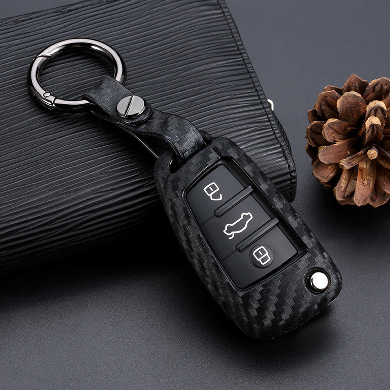 Key fob cover for Audi keys – carbon-look silicone – fitted with a metal keyring on a flat surface
