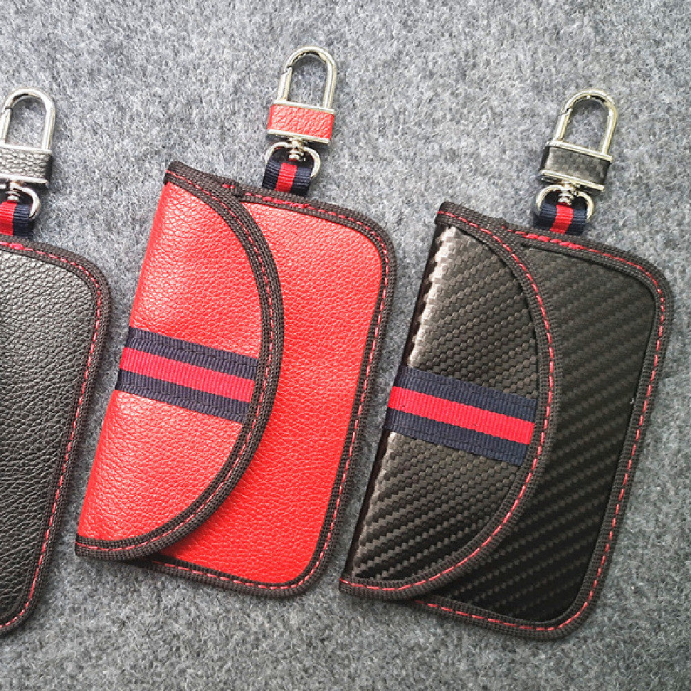 RFID signal-blocking car key case – leather or carbon-look – three colour variants on grey fabric background