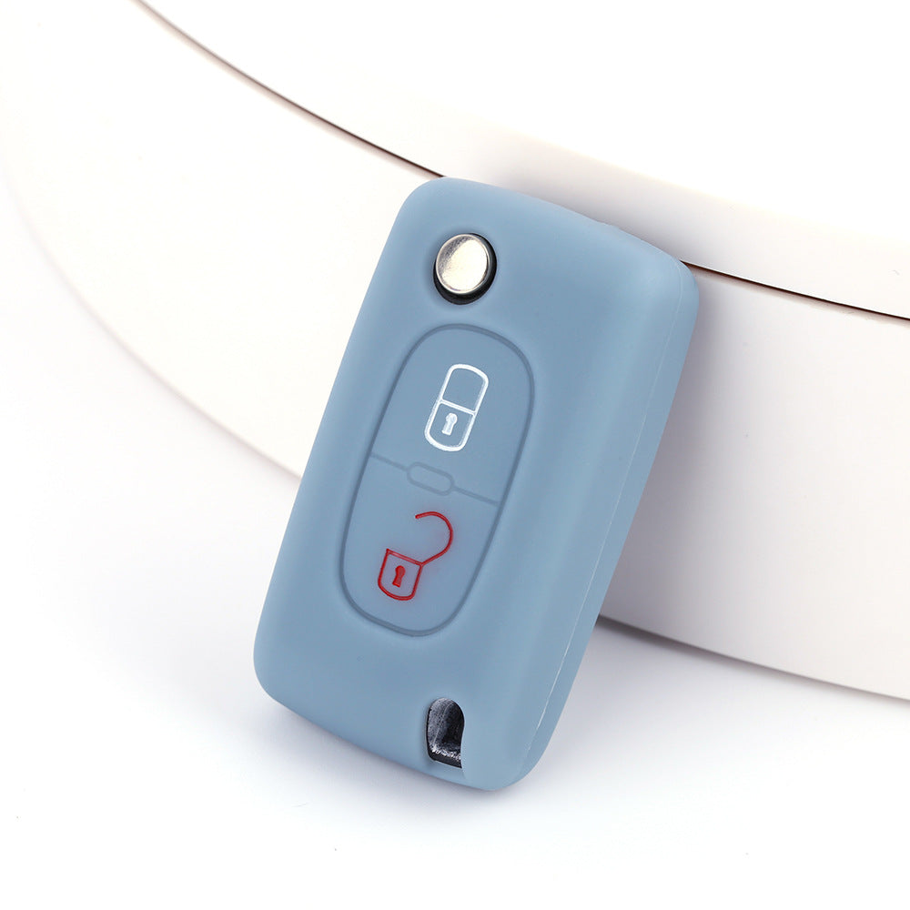 Key fob cover for Peugeot 2-button folding keys – silicone – slate blue silicone cover on white surface