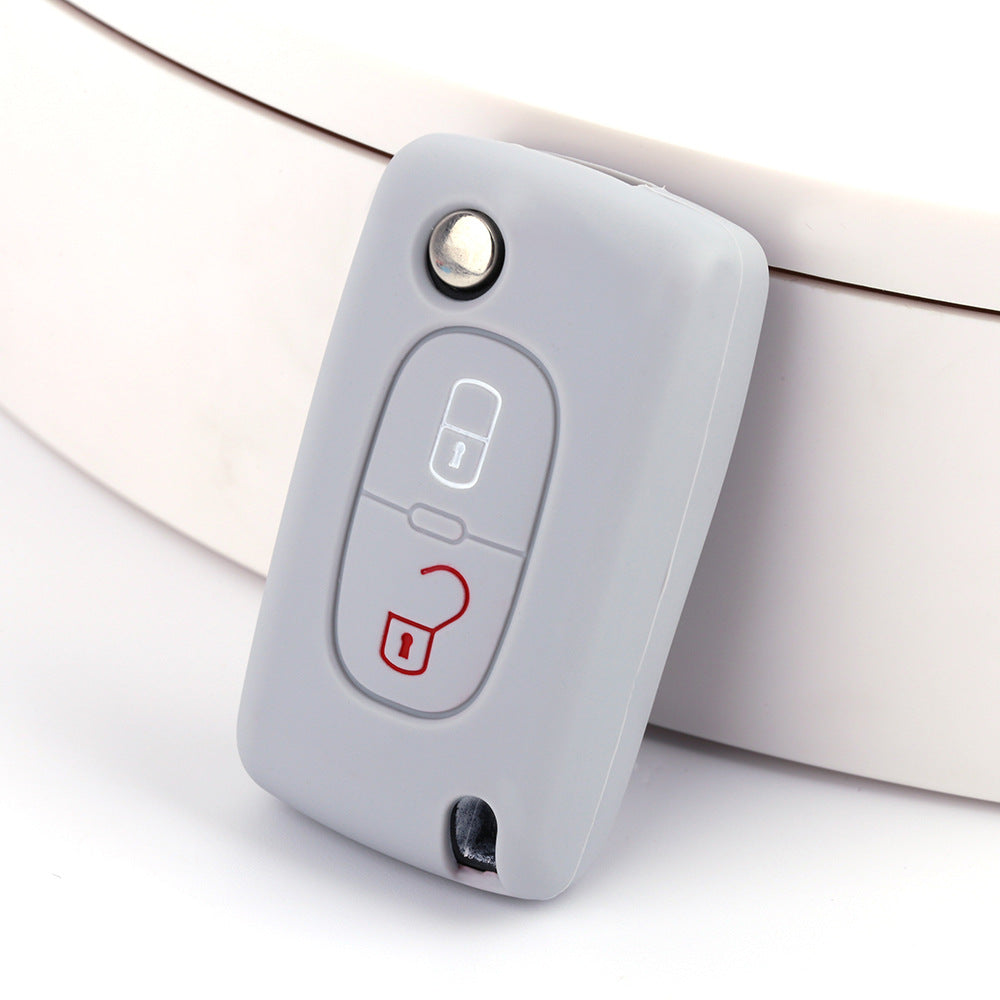 Key fob cover for Peugeot 2-button folding keys – silicone – grey silicone cover on white surface