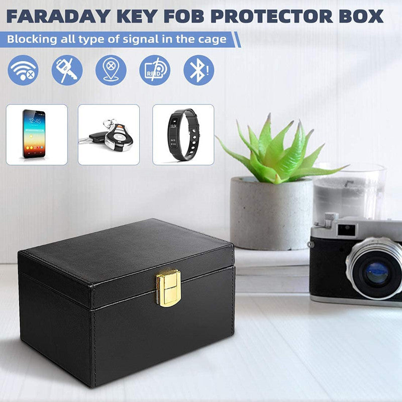 Faraday key box with 2 signal-blocking key pouches – black leather box on a desk with camera and plant